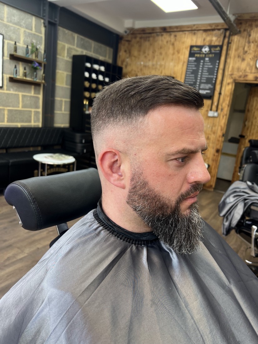A client with a neatly sculpted beard and clean fade at Golden Razor Barbers